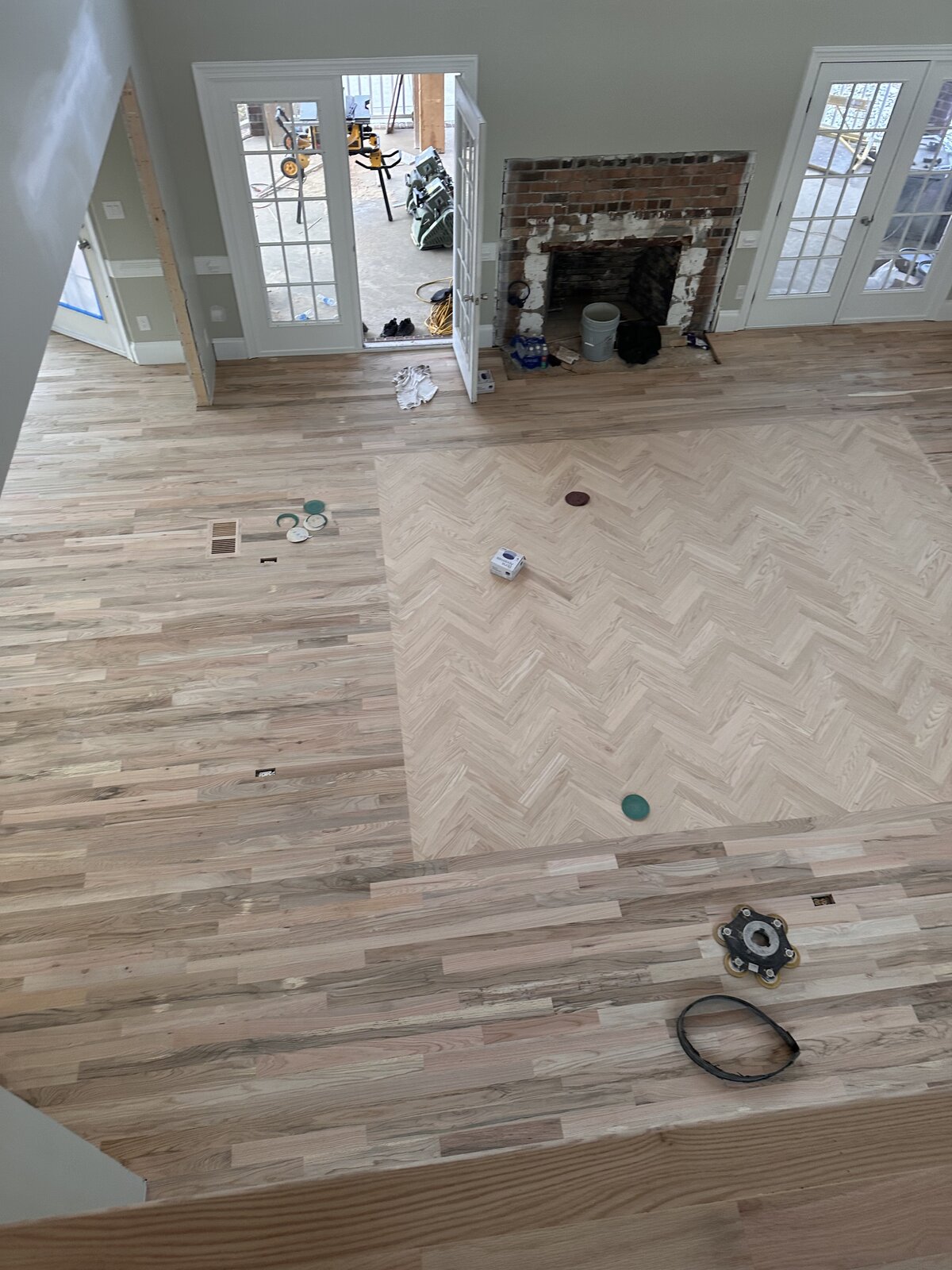 Before: full herringbone pattern laid around stone fireplace, not yet stained