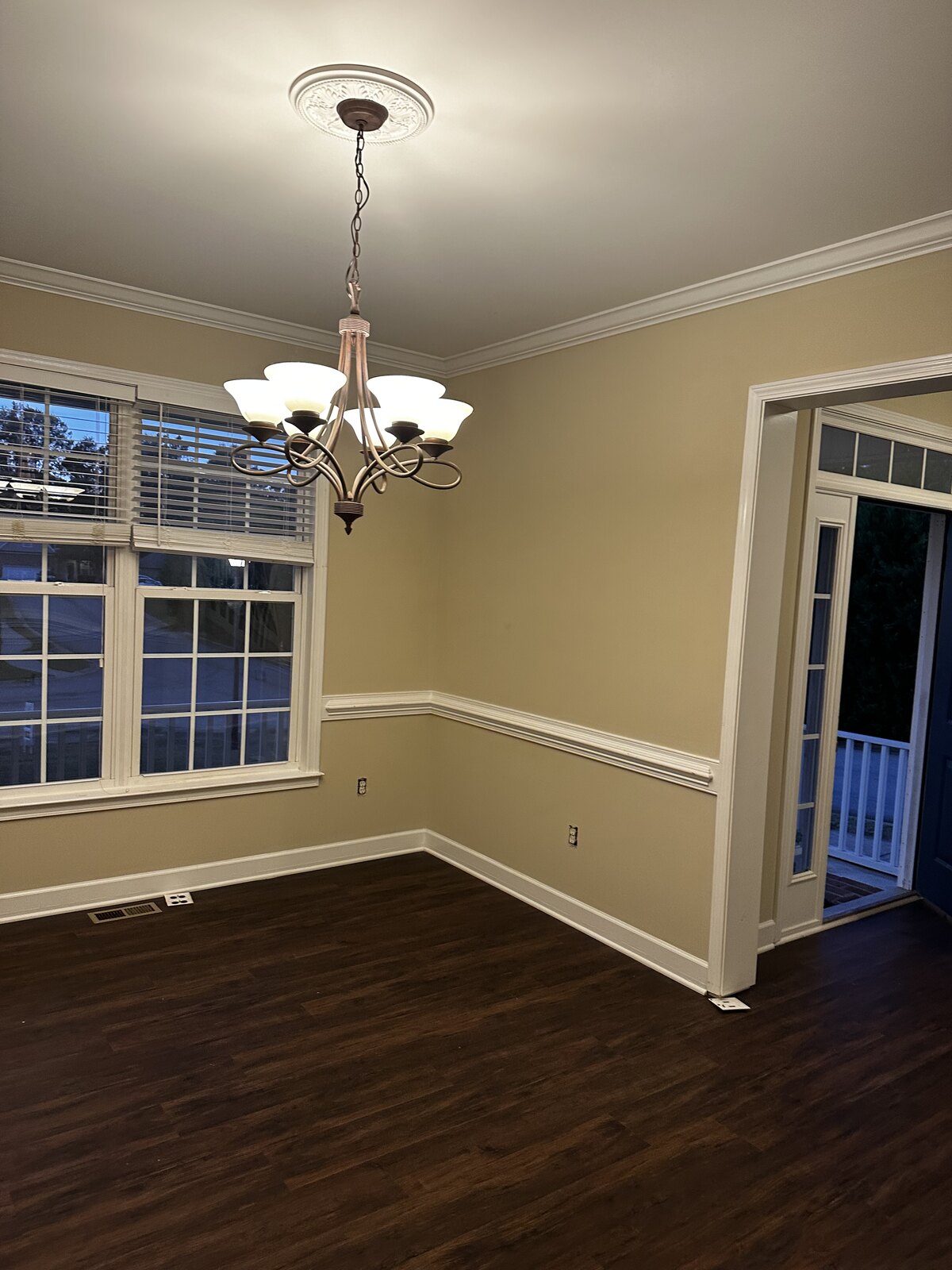 Dining room with dark hardwood floors, chandelier and crown molding