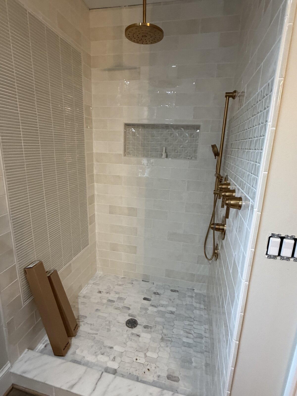 Finished: walk-in shower with marble tile and gold rainfall fixtures