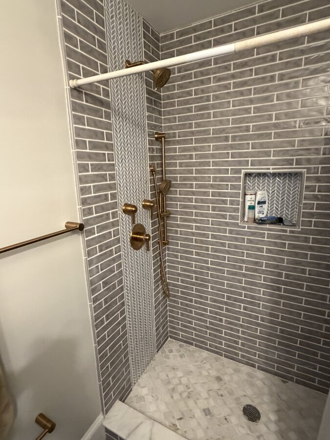 Finished: completed shower with gold towel bar and glass enclosure