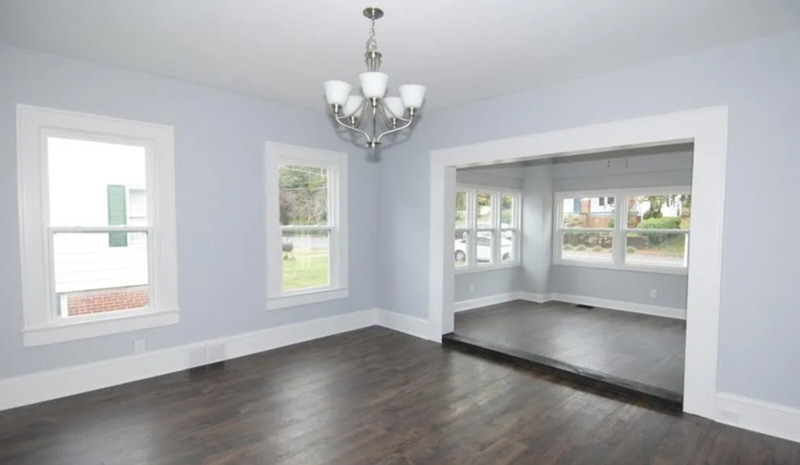 Elegant dining room with chandelier, hardwood floors and large windows