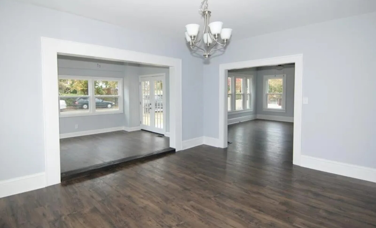 Renovated living room with dark hardwood floors, chandelier and open floor plan