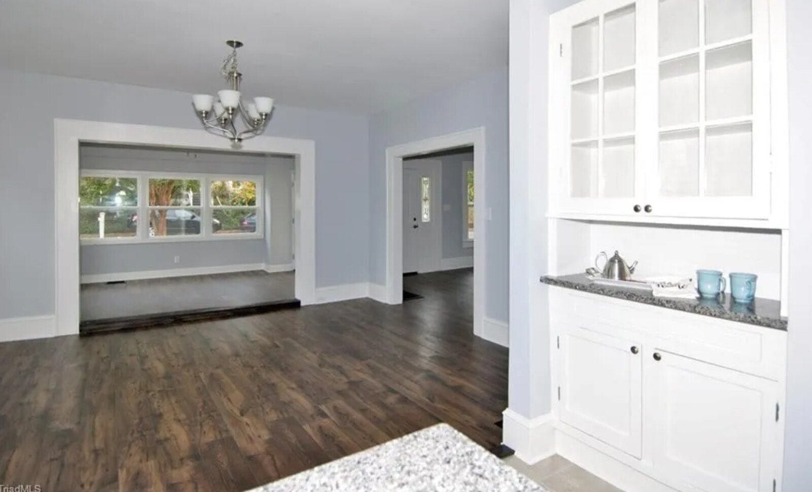 Open living room with hardwood floors, built-in cabinetry and natural light