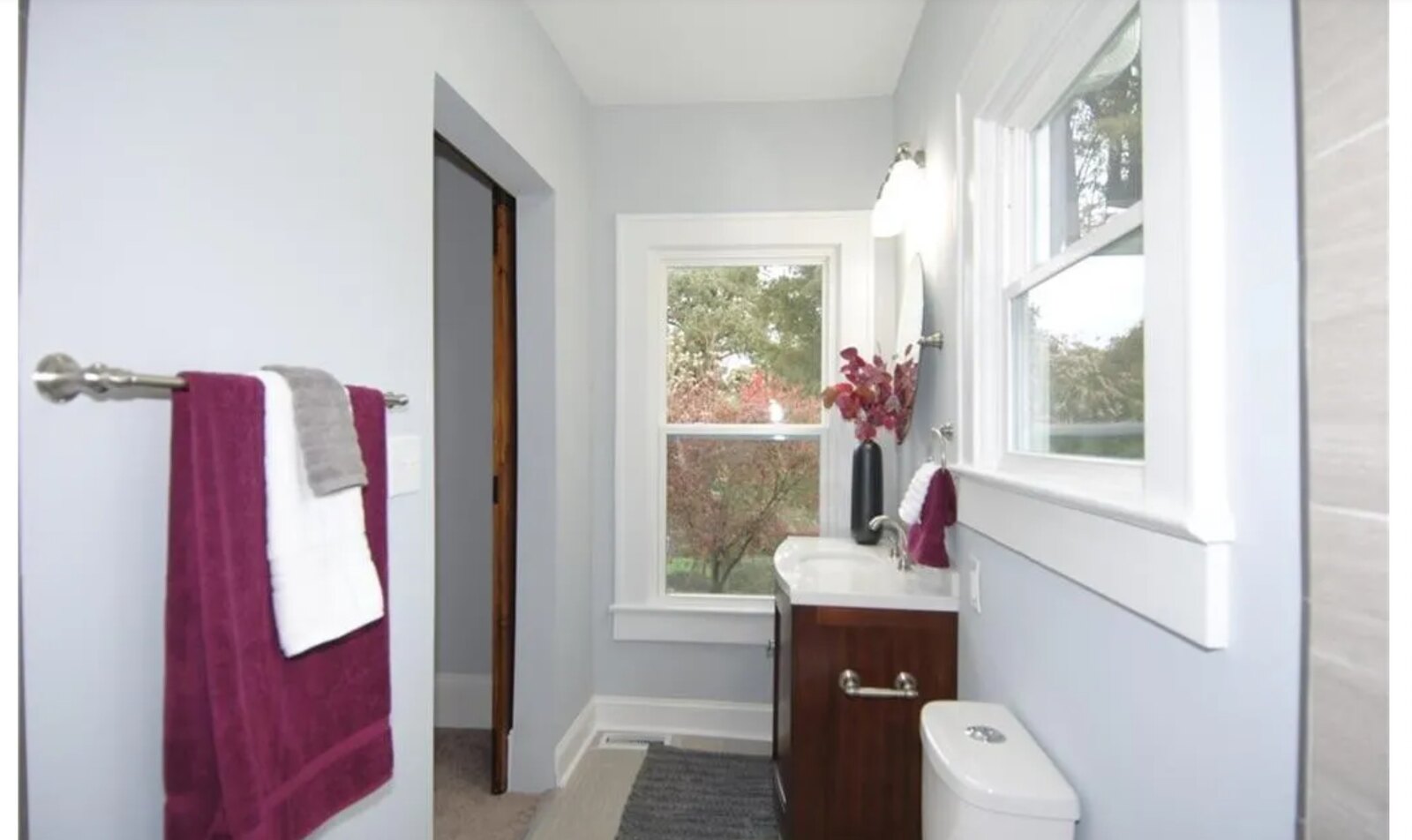 Walk-in shower with gray tile walls, pebble stone floor and river rock niche